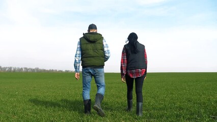 Wall Mural - happy family of farmers teamwork a red neck works go on the green field. man and girl farmer are studying eco farming farming harvesting concept. woman and lifestyle worker go walking on agricultural