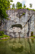 Great view of the famous lion monument, nestled in a rocky grotto in a charming park setting in Lucerne. The landmark can be seen as a commemoration, a work of art or a memorial. 