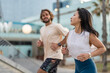 © lordn - Cheerful young multi-ethnic urban couple running alongside the beach wearing casual summer sport clothing. Jogging in the city