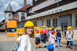 Portrait happy woman tourist wear yellow safety helmet equipment at Rammelsberg Unesco Mine trip entrance group tour. Tourism at industrial miner area Goslar Harz, Germany. Extreme mountain adventure