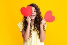 Happy Teenager Portrait. Lovely Romantic Teenage Girl Hold Red Heart Symbol Of Love For Valentines Day Isolated On Yellow Background. Smiling Girl.