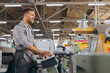 © anatoliycherkas - Factory male bearded worker is programming a CNC milling machine with copy space.