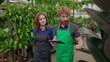 © Marco - Joyful Redhaired Staff Colleagues Exploring Flower Shop with Tablet. Green-Aproned Man and Woman Embracing Technology in Local Plant Business