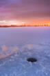 Ice fishing on a frozen lake at Sunrise