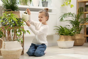 Canvas Print - Cute little girl watering beautiful green plant at home. House decor