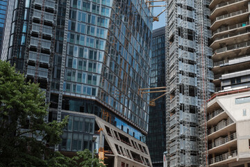 Exterior dense architectural detail modern facade of High-rise office buildings and construction site of sky-rise building. Abstract Urban metropolis background.