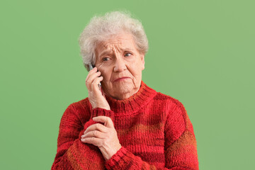 Sticker - Sad senior woman talking by mobile phone on green background, closeup