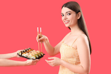 Sticker - Young woman taking sushi on red background