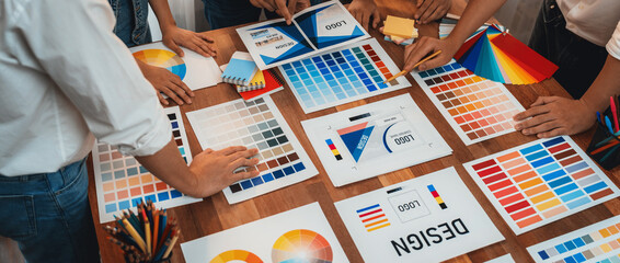 Poster - Graphic designer brainstorm logo and graphic art at busy creative studio workshop. Experiment and brainstorm color palette and pattern at workspace table for creative design. Panorama shot. Scrutinize