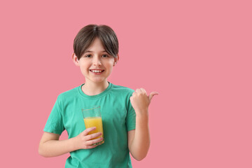 Sticker - Little boy with glass of orange juice pointing at something on pink background