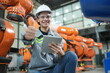 © FotoArtist - Portrait of Female Automotive Industry 4.0 Engineer in Safety Uniform Using Laptop at Car Factory Facility. Assembly Plant. engineer working at automated AI robotic production factory..