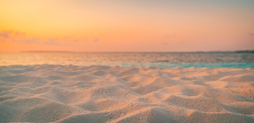 Wall Mural - closeup beach coast sand texture with warm gold orange sunset light. fantasy beach landscape sky sea