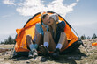 © qunica.com - Female hikers sitting in front of tent and gossiping their boyfriends. They are laughing