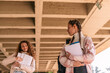 © qunica.com - Two girls standing at school yard holding books