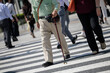 杖をついて横断歩道を渡る男性高齢者