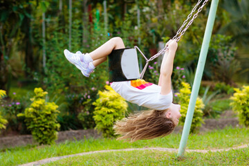 Wall Mural - Child swinging on playground. Kids swing.