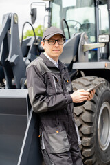 Sticker - Serviceman with digital tablet on a background of the tractor.