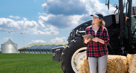 Sticker - Woman farmer with a digital tablet and agricultural tractor on a background of modern farm.