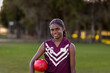 © Austockphoto - female aboriginal school student holding football under arm