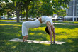 © lola - Sporty young Caucasian woman doing yoga practice concept of healthy life and natural balance between body and mental development outside in the Park