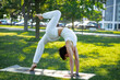 Sporty young Caucasian woman doing yoga practice concept of healthy life and natural balance between body and mental development outside in the Park