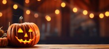 Happy Halloween Holiday Background Banner Greeting Card  - Wooden Table With Carved Glowing Pumpkin And Blurred Background With Bokeh Lights (Generative Ai)