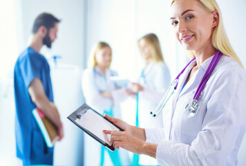 Wall Mural - portrait of a young female doctor, with aipads in hand, in a medical office