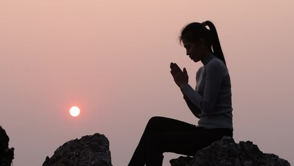 Wall Mural - Silhouette of woman Praying hands with faith in religion and belief in God On the morning sunrise background. Namaste or Namaskar hands gesture, Pay respect, Prayer position.