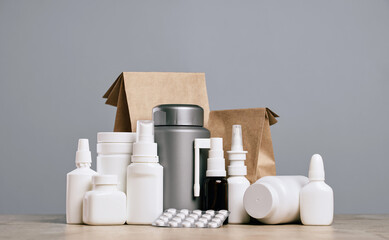 Wall Mural - Online pharmacy. prescription drugs and over the counter medication ready for delivery to customers. Pills and spray white mockup containers and buff paper bags on table. Drugstore shopping