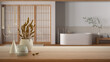 Wooden table, desk or shelf close up with ceramic and glass vases with dry plants, straws over blurred view of japandi wooden bathroom in minimal style, interior design concept