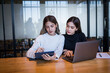 © EduLife Photos - Two cheerful young Asian female college students working on the school project using laptop computers and tablets together in private study room