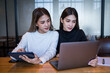 © EduLife Photos - Two cheerful young Asian female college students working on the school project using laptop computers and tablets together in private study room