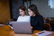 © EduLife Photos - Two cheerful young Asian female college students working on the school project using laptop computers and tablets together in private study room