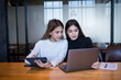 © EduLife Photos - Two cheerful young Asian female college students working on the school project using laptop computers and tablets together in private study room
