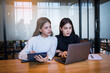 © EduLife Photos - Two cheerful young Asian female college students working on the school project using laptop computers and tablets together in private study room