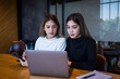 © EduLife Photos - Two cheerful young Asian female college students working on the school project using laptop computers and tablets together in private study room