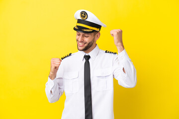 Wall Mural - Airplane caucasian pilot isolated on yellow background celebrating a victory