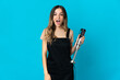 © luismolinero - Romanian woman using hand blender isolated on blue background with surprise facial expression