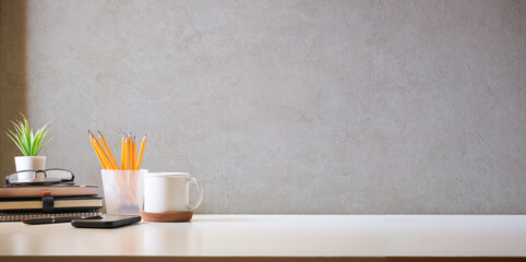 Wall Mural - Comfortable workplace with coffee, stationery and houseplant on white table. Home office, copy space.