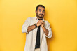 © Asier - Casual young Latino man against a vibrant yellow studio background, scared and afraid.