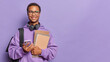© WHstudio Leushin N - Modern student poses with textbooks and smartphone has dreamy expression returns after classes in university carries rucksack isolated over purple background copy space for your advertising content