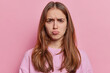 Displeased young European woman smirking face reveals deep mistrust as she vehemently disagrees with someones suspicious idea feels offended dressed in casual pullover isolated over pink background