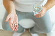 © DG PhotoStock - Unwell caucasian man got a sickness, oversize fat man taking a pills and drinking water in a drinking glass after wake up in morning.