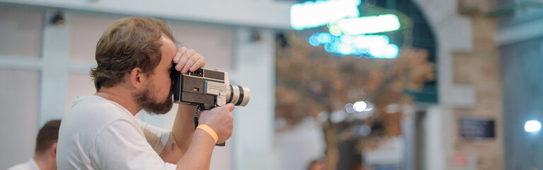 Wall Mural - Director of photography with a camera in his hands on the set. Professional videographer at work on filming a movie