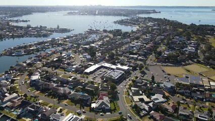 Wall Mural - Aerial drone view above Sylvania Waters in the Sutherland Shire, Sydney, NSW Australia looking toward Captain Cook Bridge on Georges River on a sunny day in June 2023 