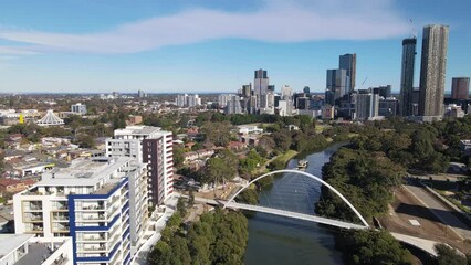 Wall Mural - Aerial drone view above Parramatta River in Greater Western Sydney, NSW, Australia with Parramatta CBD in the background as a ferry travels to Parramatta Wharf  