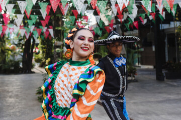 Wall Mural - Latin couple of dancers wearing traditional Mexican dress from Guadalajara Jalisco Mexico Latin America, young hispanic woman and man in independence day or cinco de mayo parade or cultural Festival