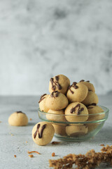 cake ball with chocolate on topping. indonesian cake or cookies. served on wooden place map in grey and texture background. inscription N with chocolate