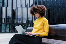 Young African American Business Woman Using Laptop Or Computer In City Of Latin America, Hispanic Financial And Caribbean People With Skyscraper Background