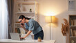 © golubovy - Online management. Remote communication. Smart busy woman employee discussing work project speaking on phone using laptop at modern home workplace interior with free space.